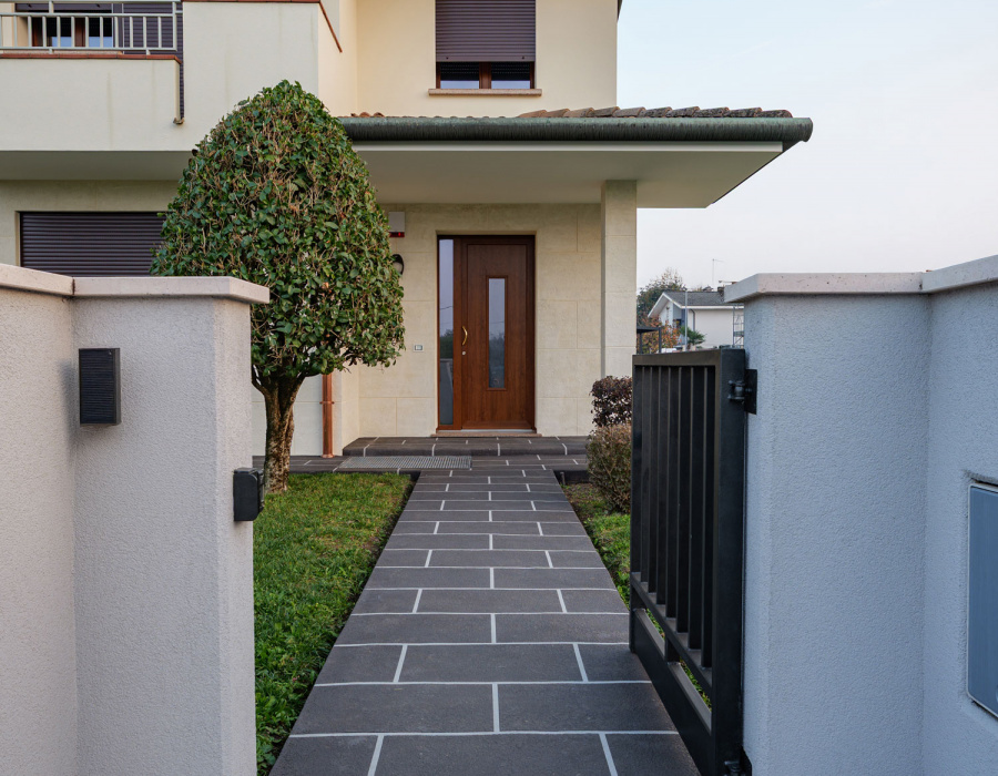 Muretto di ingresso con rivestimento decorativo a intonaco strutturato su superficie esterna residenziale