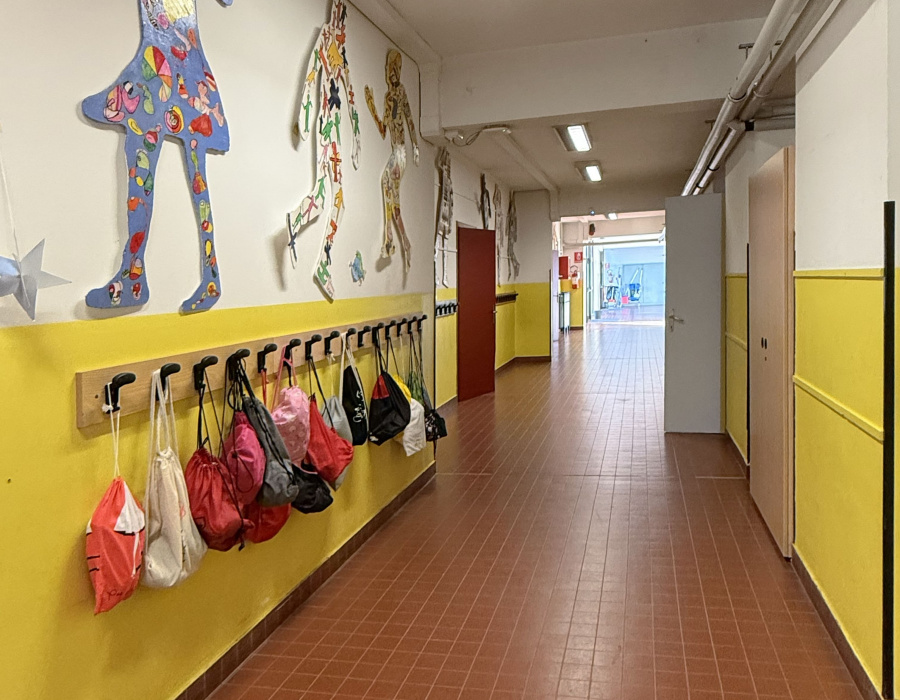 Corridoio scolastico con pareti gialle rivestite in Isoplast Isocolor, rivestimento murale continuo lavabile